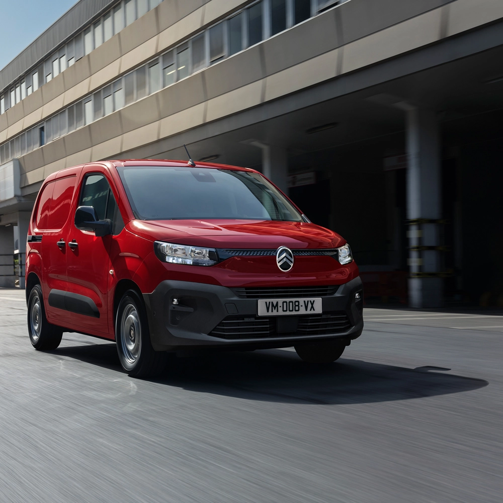 Vooraanzicht van een rode Citroën Berlingo Van die op de weg rijdt