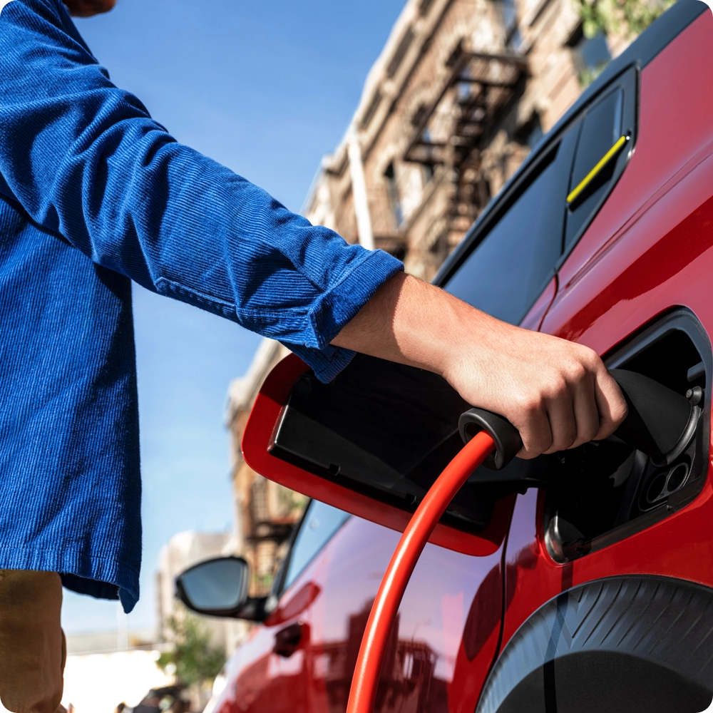 Vue rapprochée de la trappe de recharge de l’ë-C3 Van connectée à un câble, illustrant la simplicité de la recharge et la mobilité électrique zéro émission.