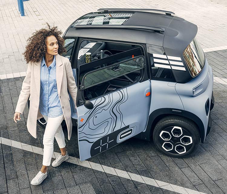 Молодая женщина, выходящая из друга Citroën, открытая дверь