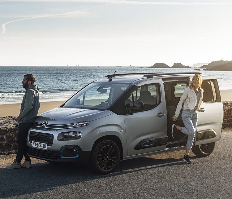 Мужчина и женщина возле Citroën ë-Берлино припарковались возле пляжа