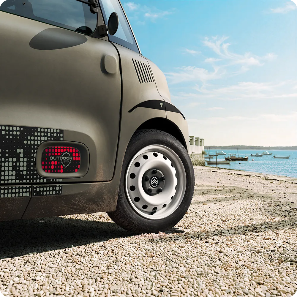 Gros plan sur les roues en acier blanches de Citroën Ami Outdoor présentant un véhicule urbain électrique compact pour les déplacements quotidiens