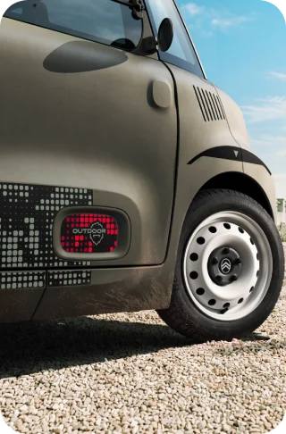 Gros plan sur les roues en acier blanches de Citroën Ami Outdoor présentant un véhicule urbain électrique compact pour les déplacements quotidiens