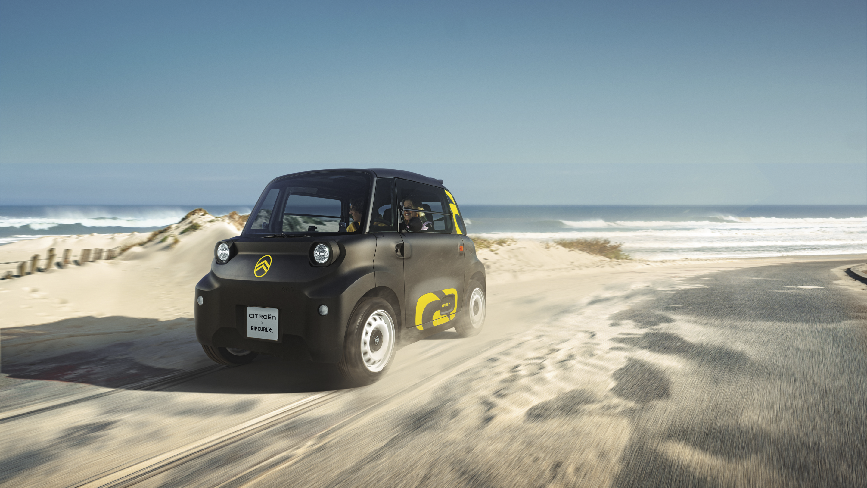 Actieaanzicht driekwart vooraanzicht van de Citroën Ami x Rip Curl elektrische wagen zonder rijbewijs, Citroën Ami staat voor vrijheid in stedelijke elektrische mobiliteit