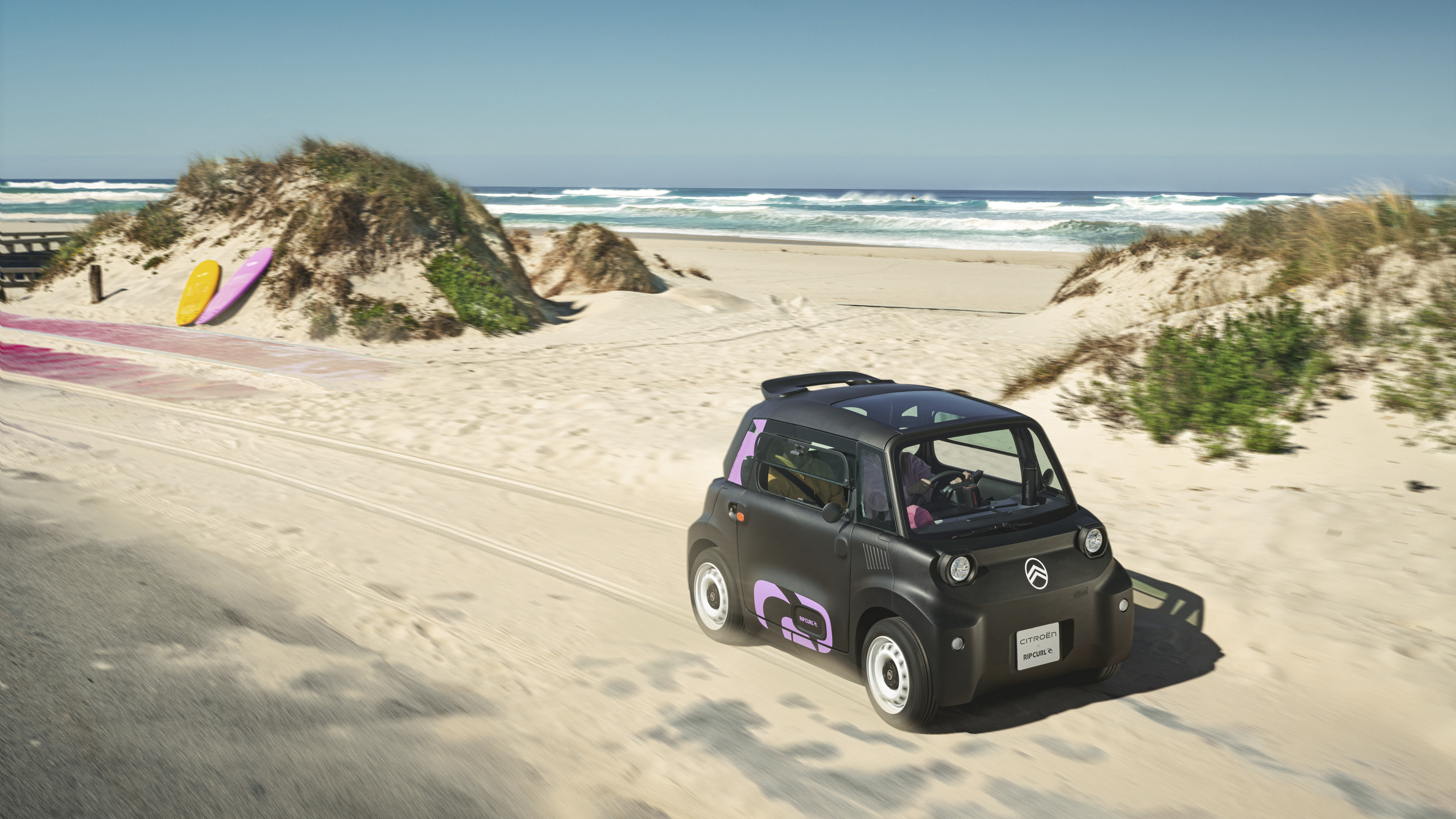 Actieaanzicht driekwart vooraanzicht van de Citroën Ami x Rip Curl elektrische wagen zonder rijbewijs, Citroën Ami staat voor vrijheid in stedelijke elektrische mobiliteit