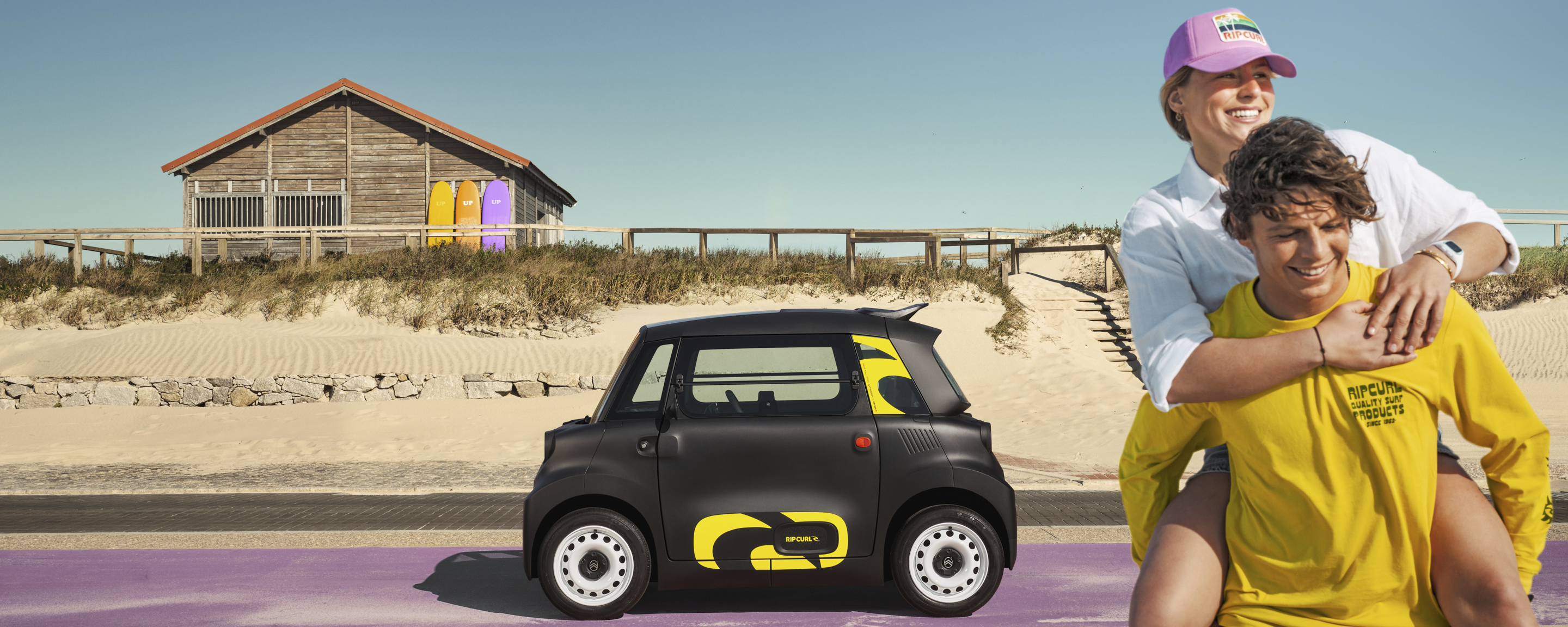Lifestyle zijaanzicht van de Citroën Ami x Rip Curl elektrische wagen zonder rijbewijs, Citroën Ami staat voor vrijheid aan zee voor stedelijke elektrische mobiliteit
