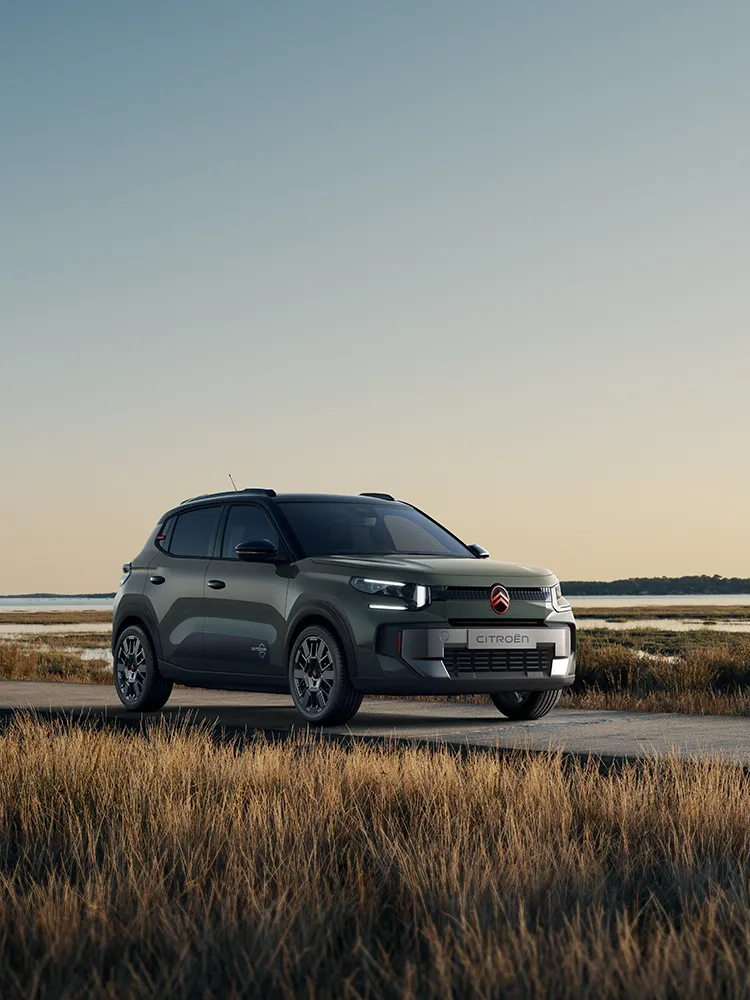 Vue avant trois-quarts de Citroën C3 Outdoor avec signature lumineuse LED, présentant un SUV Advanced Comfort près de zones humides côtières