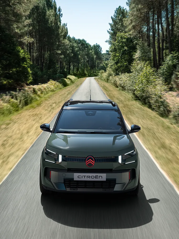 Vue avant en plongée de Citroën C3 Outdoor avec signature lumineuse LED, présentant un SUV compact Advanced Comfort sur une route forestière
