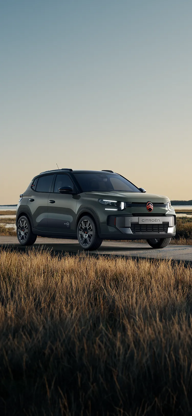 Driekwartvooraanzicht van de Citroën C3 Outdoor met LED-lichtsignatuur, die een Advanced Comfort SUV toont nabij kustmoerassen