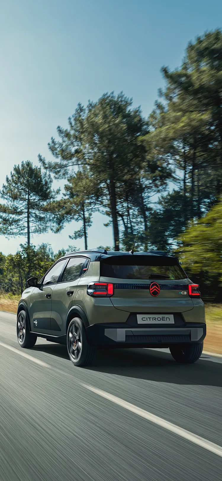 Driekwartachteraanzicht van de Citroën C3 Outdoor met LED-achterlichten, die een Advanced Comfort SUV op de openbare weg toont