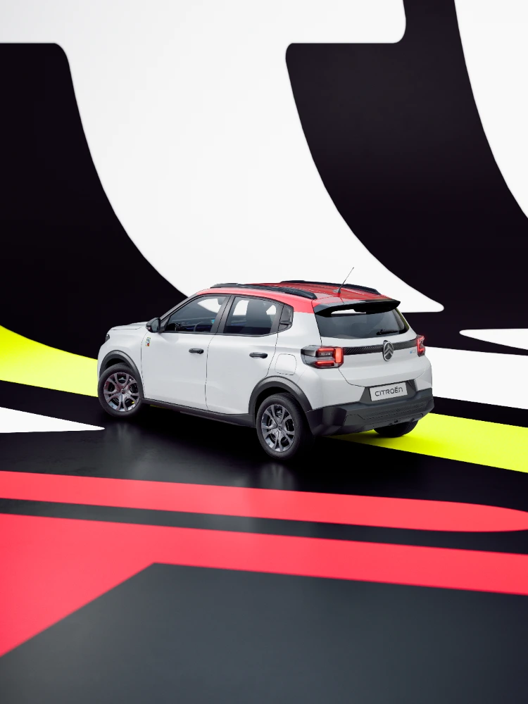 Achterkant in driekwartperspectief: Citroën ë-C3 TONIC limited edition elektrische stadswagen met opvallende grafische achtergrond en compact ontwerp, slim EV-alternatief