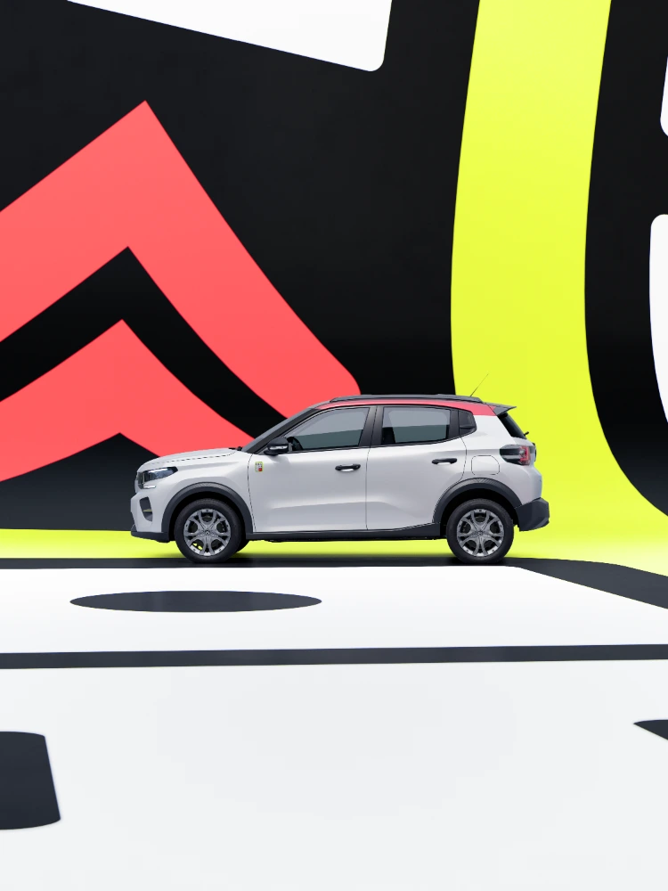 Zijprofielbeeld Citroën ë-C3 TONIC limited edition elektrische stadswagen gereden in studio-omgeving, compact ontwerp, slim EV-alternatief