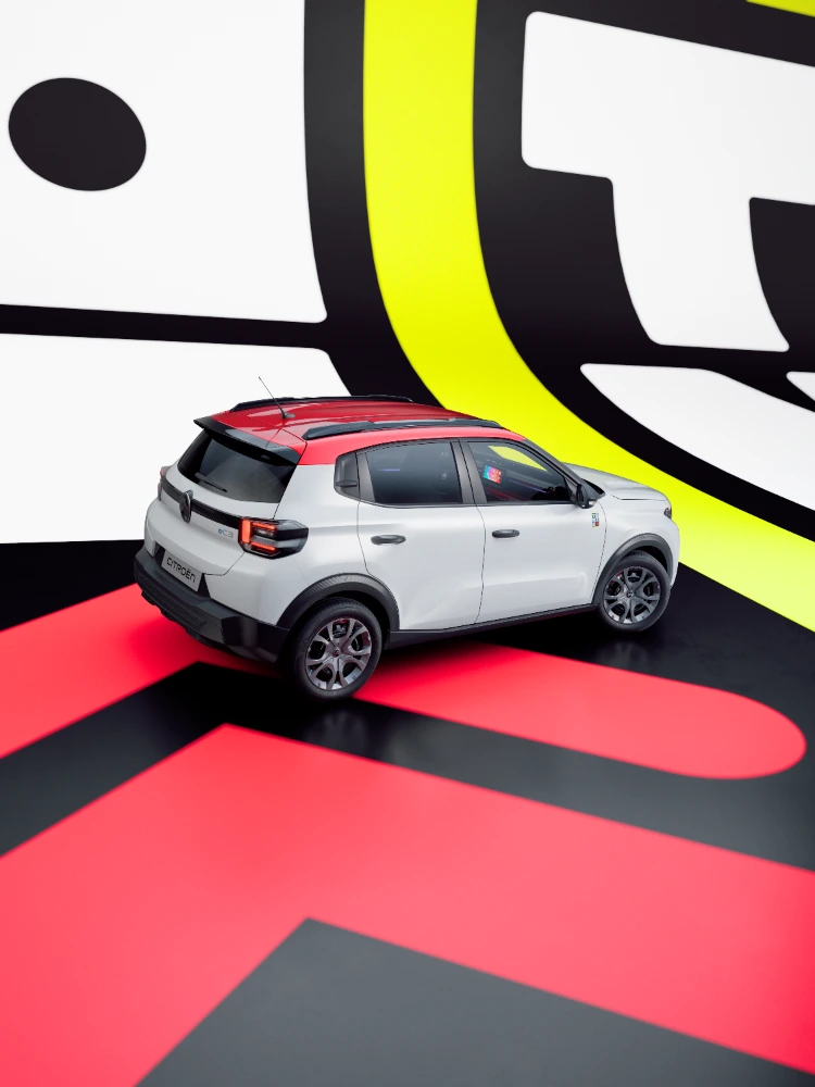 Achterkant driekwartbeeld Citroën ë-C3 TONIC limited edition elektrische stadswagen gedurfd ontwerp in studio-omgeving, slim EV-alternatief