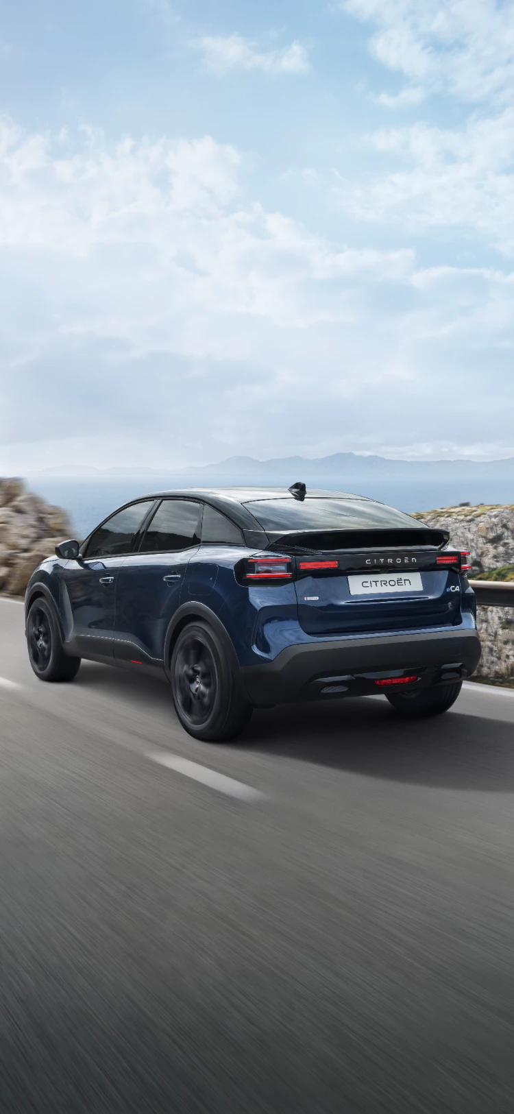 Vue trois-quarts arrière en conduite avant ë-C4 mettant en valeur le design crossover aérodynamique, l'efficacité et le style pour une présence moderne premium