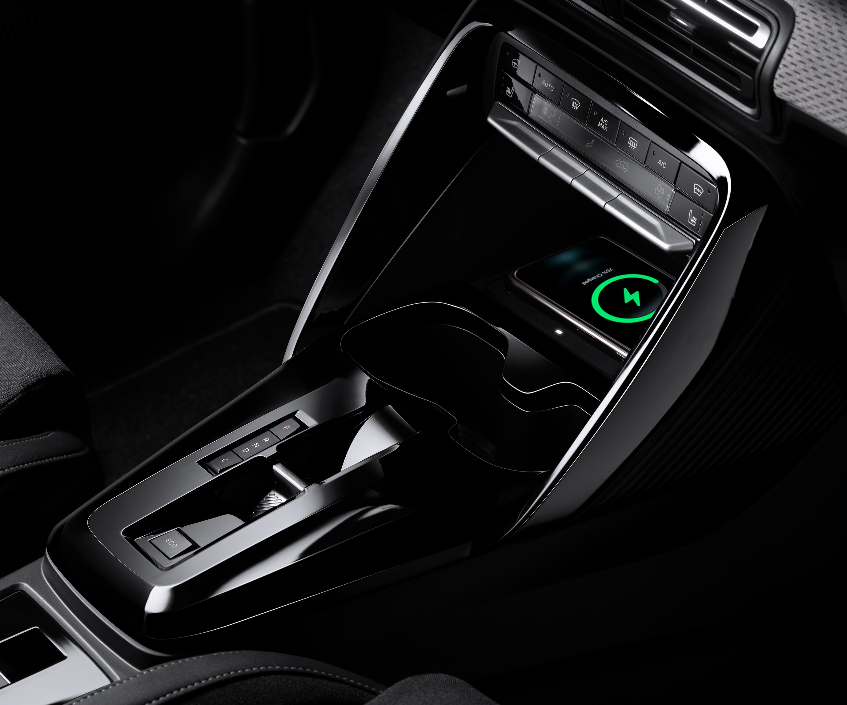 Close-up console-opname van de Citroën ë-C3 elektrische SUV benadrukt draadloos opladen voor praktische, betaalbare dagelijkse mobiliteit.