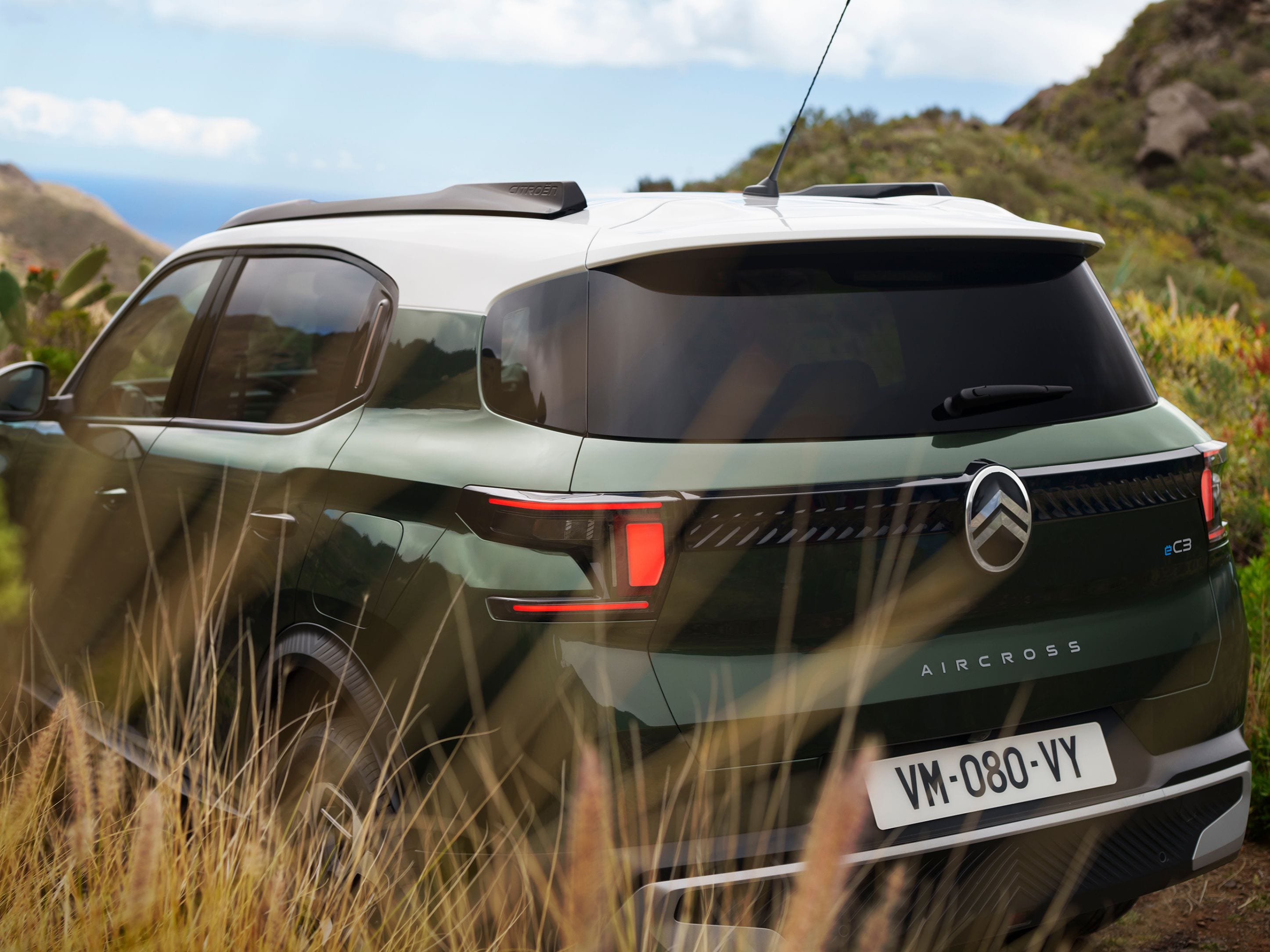 Achterste driekwart buitenaanzicht van de Citroën ë-C3 Aircross SUV benadrukt het gedurfde tweekleurige ontwerp voor zelfverzekerde, veelzijdige en betaalbare mobiliteit.