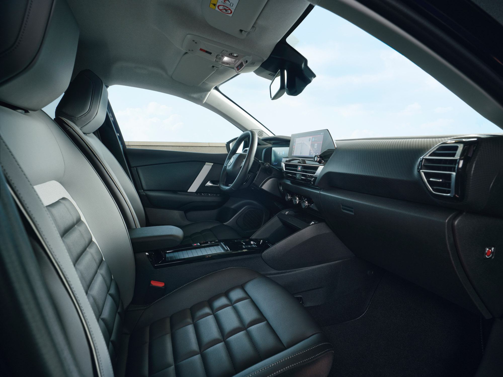 Vue intérieure frontale de la Citroën C4 X montrant les sièges, le tableau de bord et l’écran central