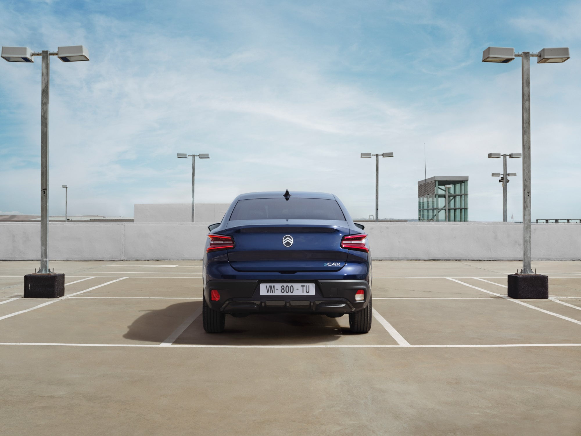 Vue arrière de la Citroën C4 X sur le parking sur le toit, mettant en valeur un fastback distinctif pour une mobilité élégante et abordable