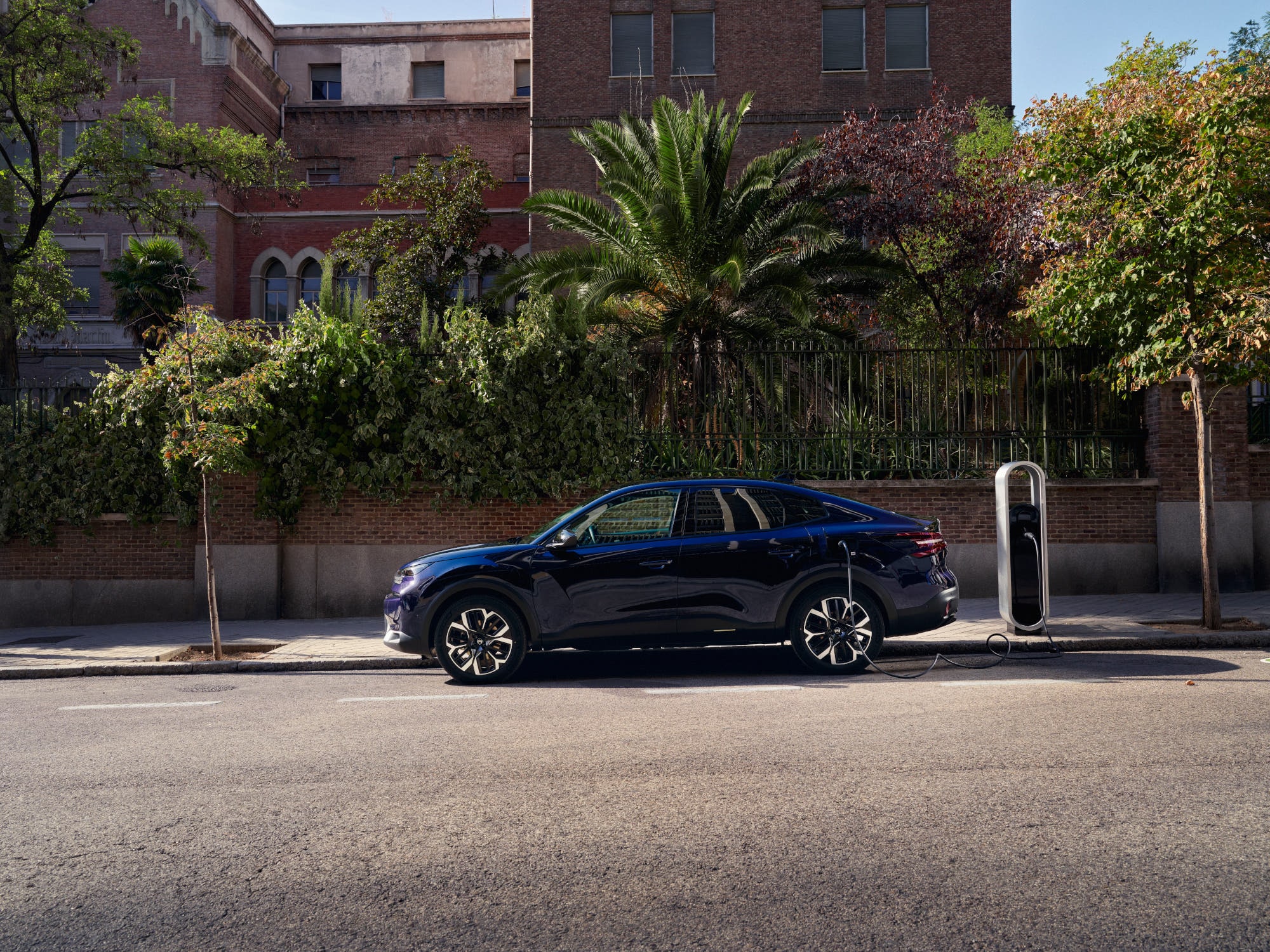 Vue latérale de la recharge électrique fastback Citroën C4 X dans la rue, mettant en avant une mobilité urbaine pratique et abordable