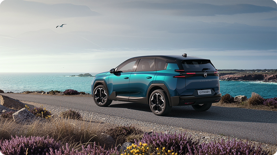 Driekwart achteraanzicht van de Citroën C5 Aircross Emeraude met Citroën Light Wings LED-achterlichten en een ruim design, gezins-SUV.