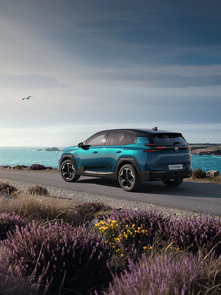 Driekwart achteraanzicht van de Citroën C5 Aircross Emeraude met de kenmerkende Light Wings LED-achterlichten van de C5 Aircross, gezins-SUV aan de kust